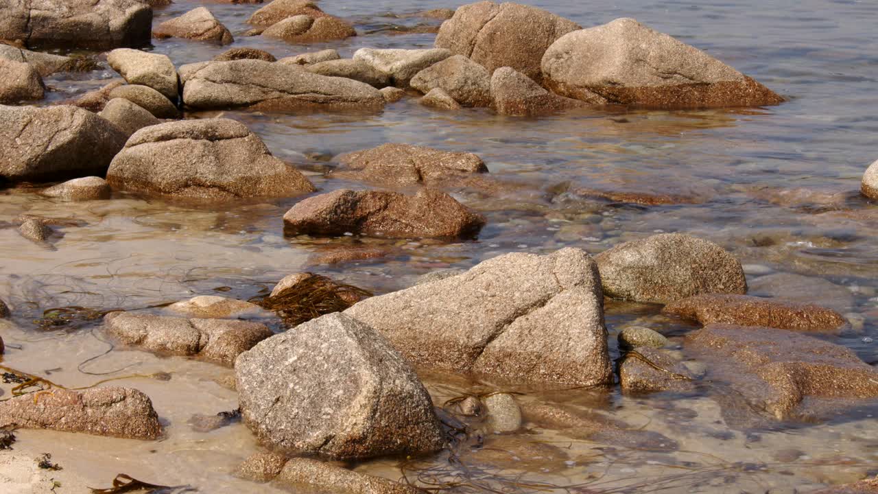 una serie de rocas erosionadas y el mar bañando alrededor entonces en la playa de st agnes en las islas de scilly 6 de 6