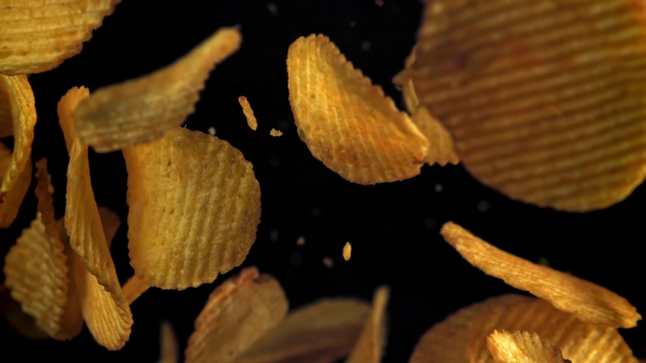 Crispy Ruffled Potato Chips Falling in Slow Motion