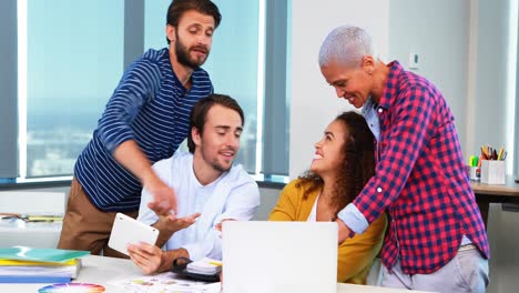 Team-of-executives-discussing-over-laptop