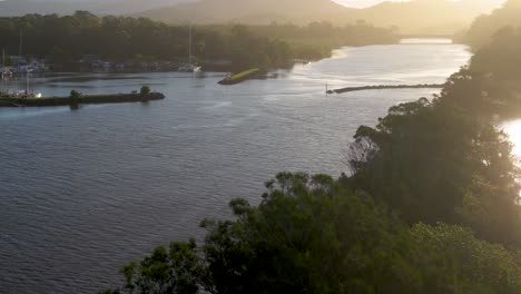 aerial view of brunswick river at sunset, highlighting lush greenery and tranquil waters under golden light