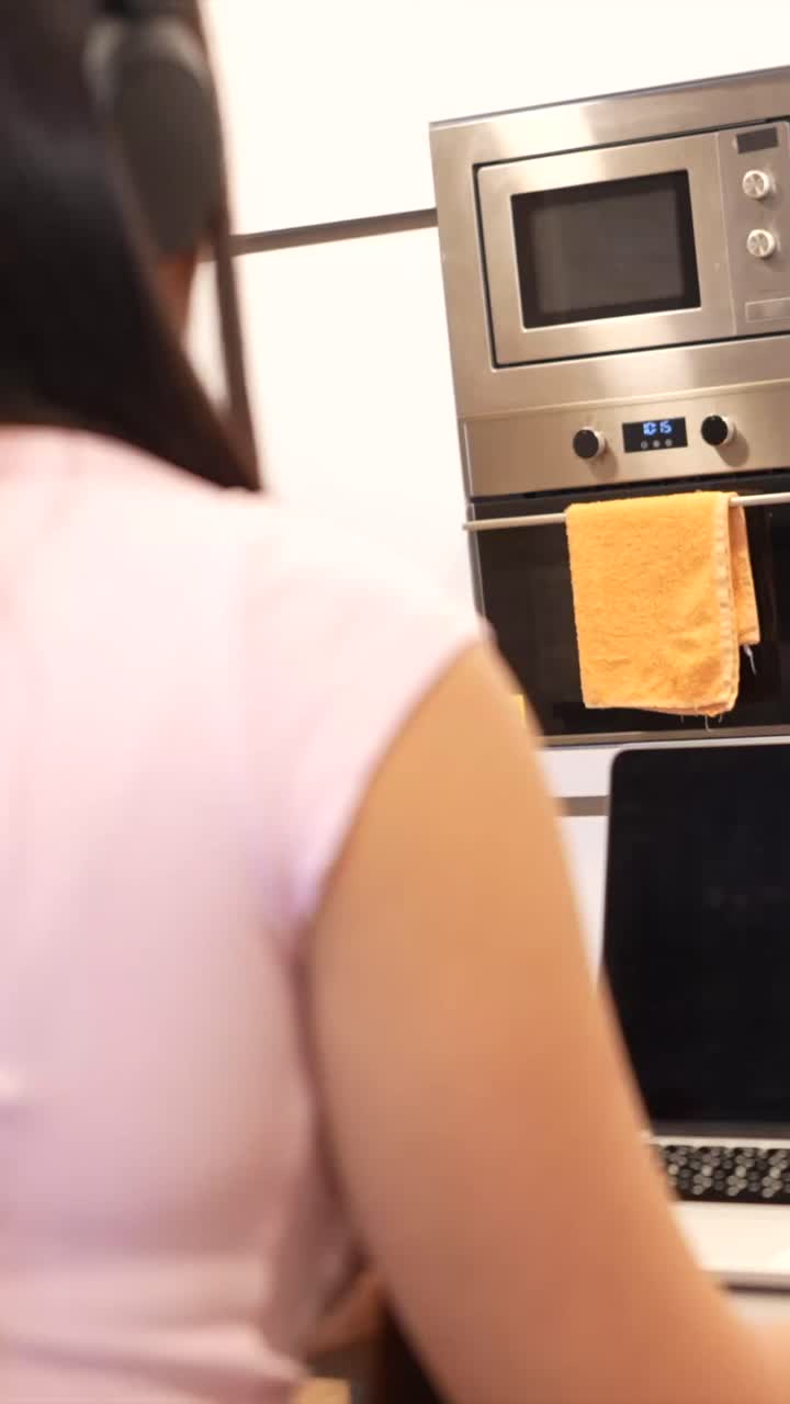 People in a kitchen with a laptop