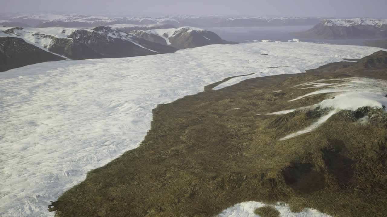 Giant glacier flows over rugged terrain in remote arctic landscape