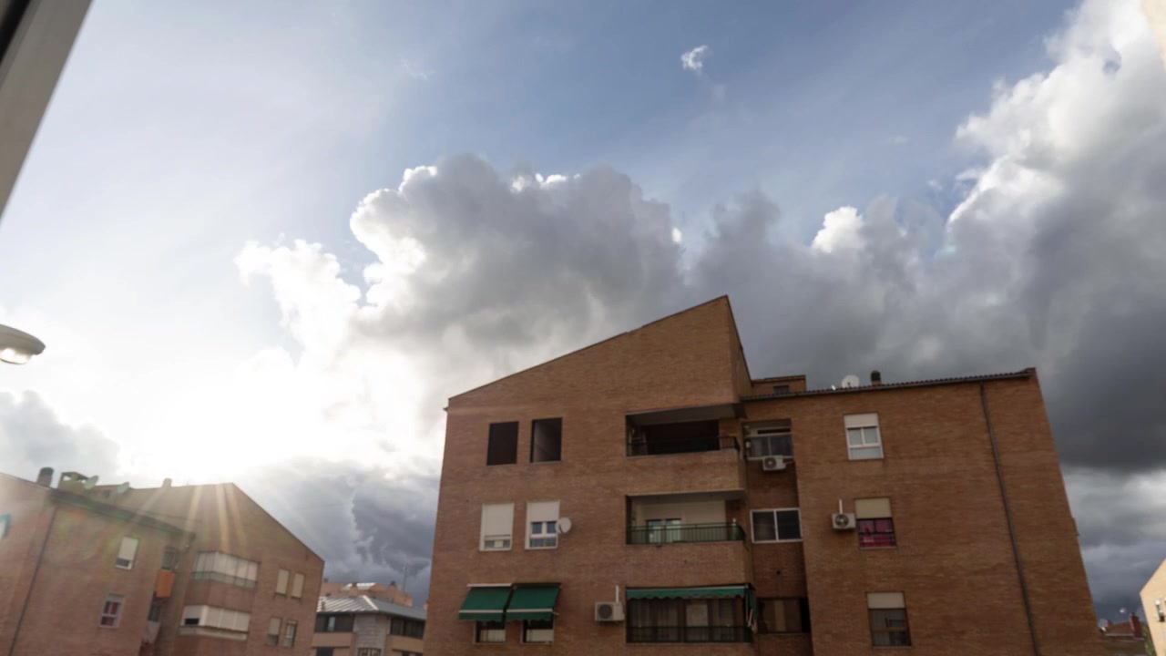 Timelapse di nuvole che passano sopra gli edifici residenziali.