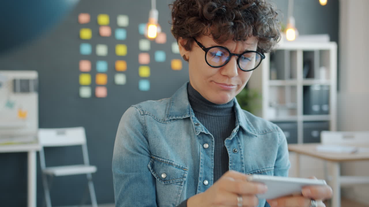 Woman Playing Mobile Game in Office
