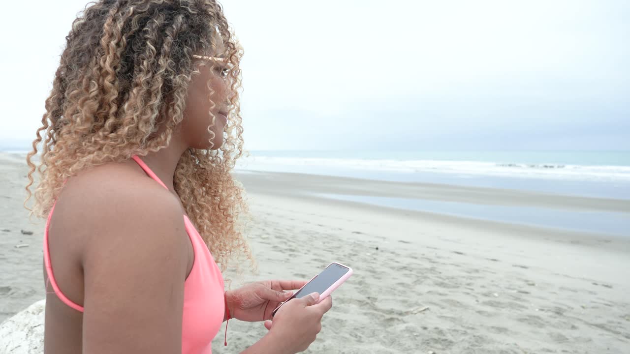 linda chica rizada mirando su teléfono