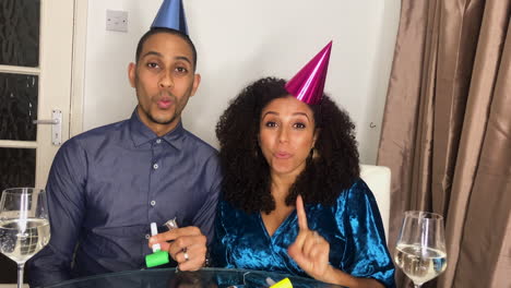 young adult couple on video call counting down to midnight and celebrating new year together