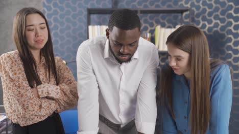 diverse team of asian business woman, black man and european woman enjoy working as a team at work.