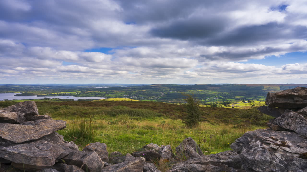 timelapse de la naturaleza rural tierras de cultivo con pared de piedra en el primer plano archivado y el lago en la distancia durante un día nublado visto desde carrowkeel en el condado de sligo en irlanda