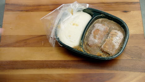 Frozen-ice-food-meal-container-being-picked-up-sideways-from-the-dining-table