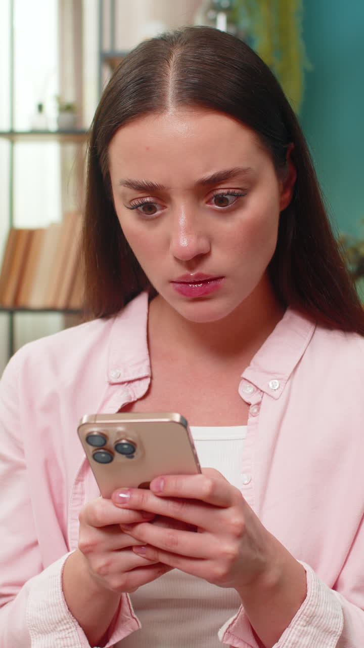Giovane donna che scrive arrabbiata al cellulare, agitando la mano frustrata dai messaggi in chat e visibilmente scoraggiata