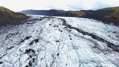 Breathtaking-aerial-view,-Sólheimajökull-glacier-unveils-its-frozen-majesty,-a-mesmerizing-wonder-in-Icelandic-wilderness