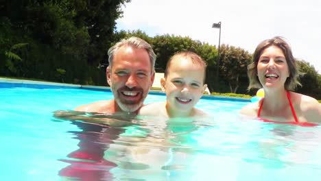 happy parents and their kids in poolside