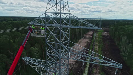 workers on high voltage pylon and surrounding landscape