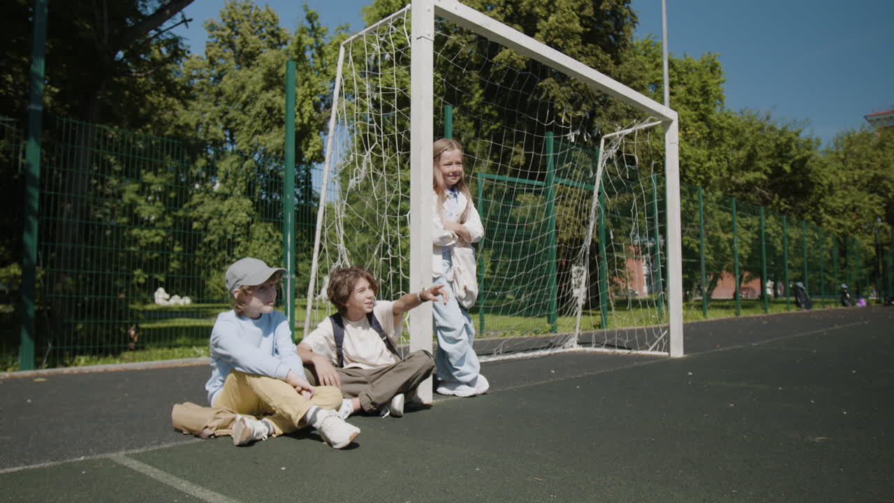 Kids relaxing and playing on an outdoor sports court
