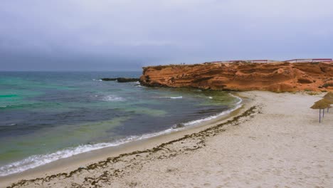 cabo rocoso vacío con playa de arena cerca del hermoso mar
