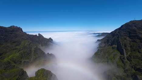 drone video of rainbow spanning cloud covered valley