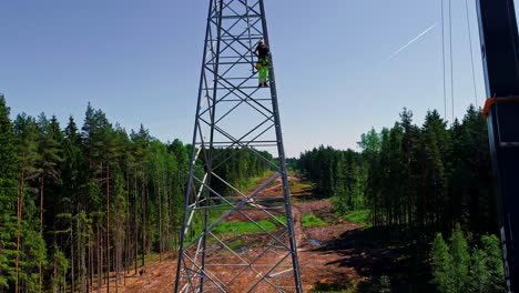 Vista-Aérea-De-Trabajadores-Profesionales-Que-Trabajan-En-La-Instalación-De-Una-Torre-De-Alto-Voltaje-En-Un-Cortafuegos-Forestal