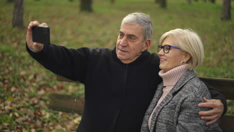 elderly couple taking a selfie in the park