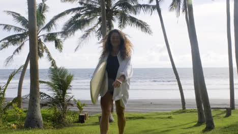 woman walking and holding surfboard