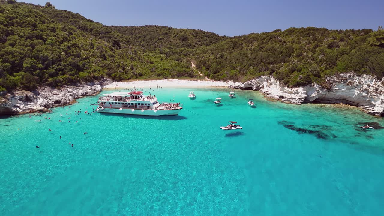Flyover ships in crystal clear water to tourists swimming in bay