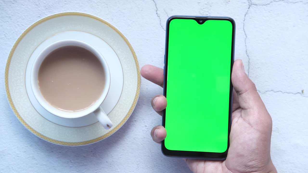 스마트 폰을 사용하고 커피를 마시는 사람의 손의 높은 각도 시각