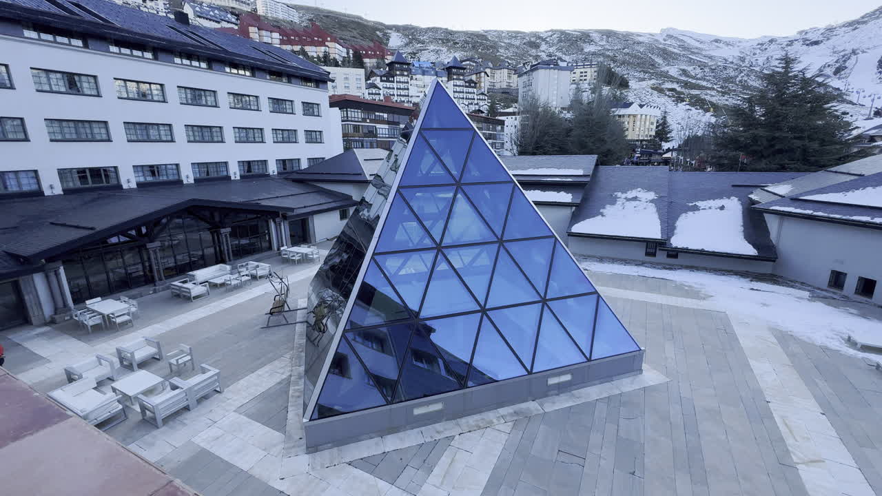 pyramid glass structure in snowy mountain town setting