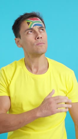 man listening to the south africa national anthem with solemnity
