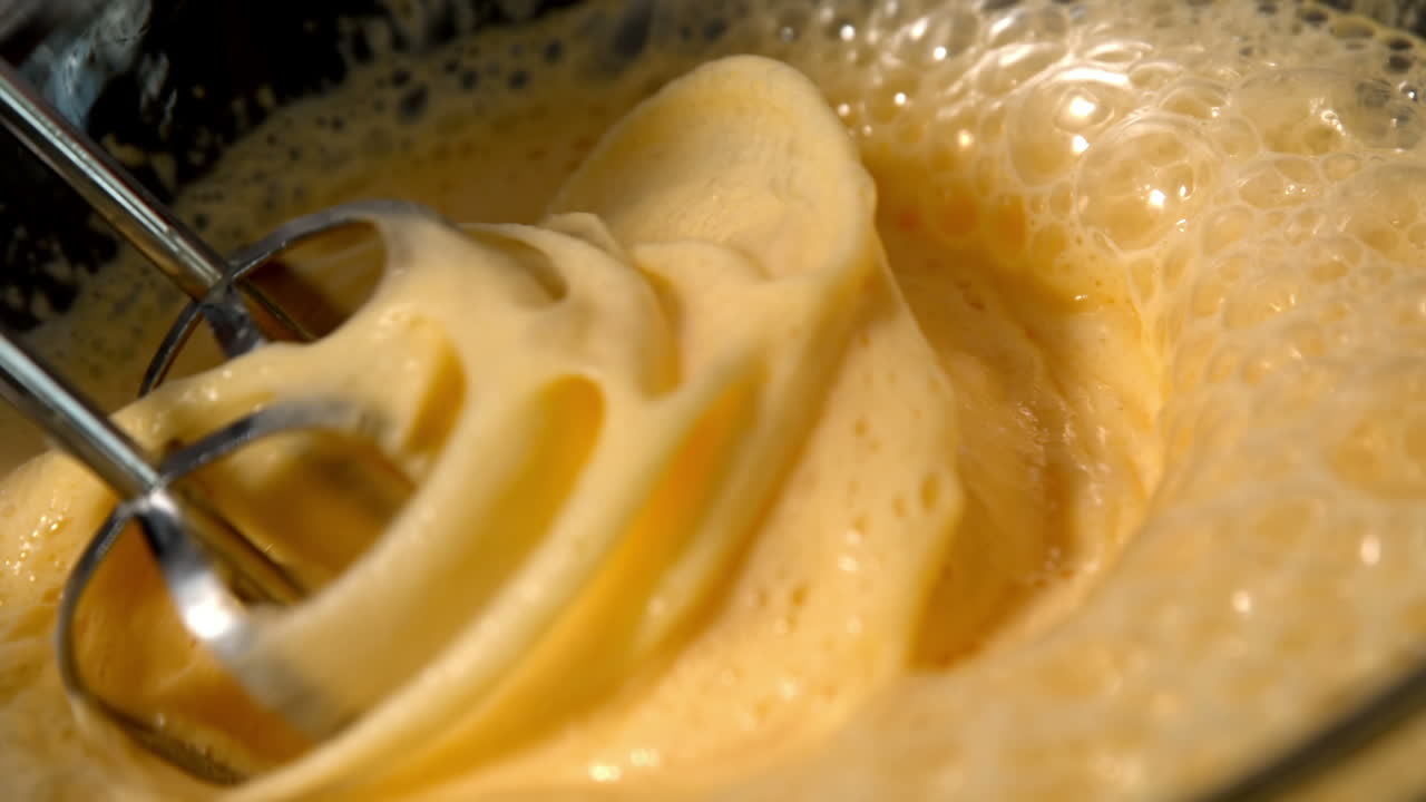 batido en un tazón de vidrio de huevo crudo