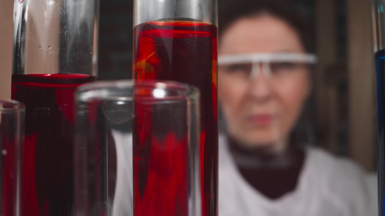 gotas de líquido rojo caen en el tubo bajo el control de la mujer