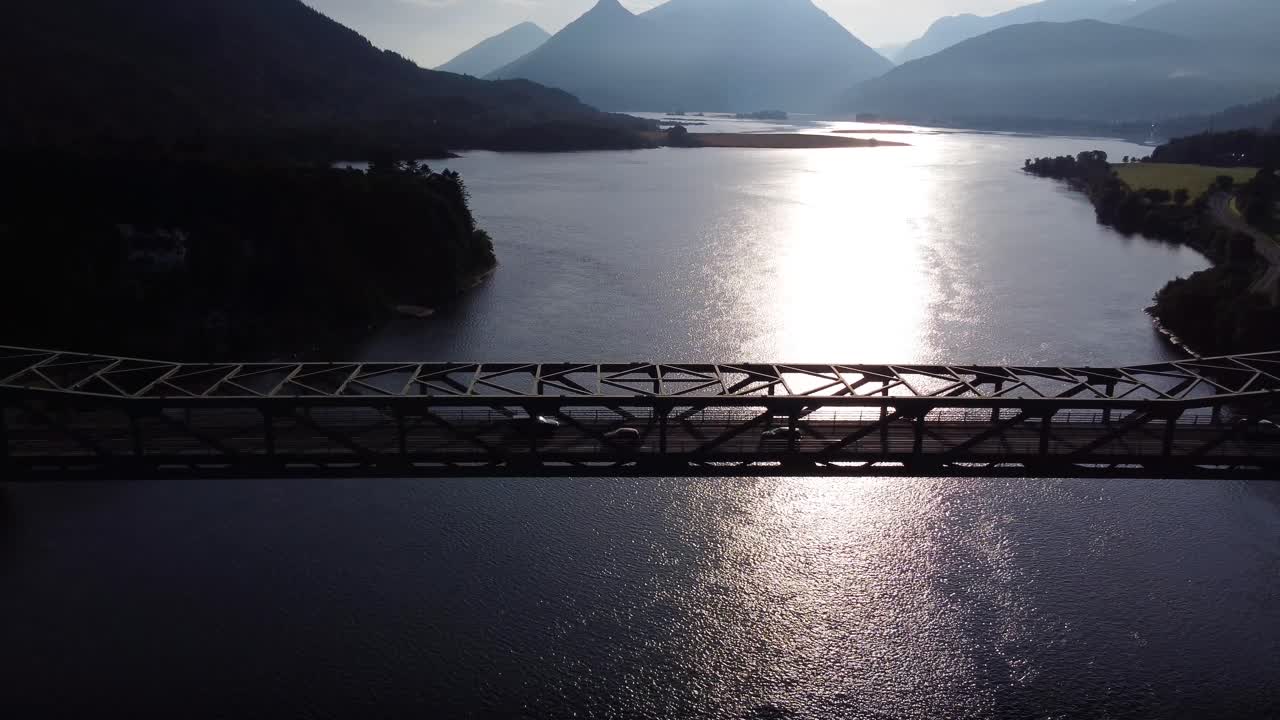 Cars Driving over Ballachulish Bridge at Loch Leven near Glencoe on the West Coast of Scotland with Morning Sun, Aerial Drone 4K HD Footage Fly In