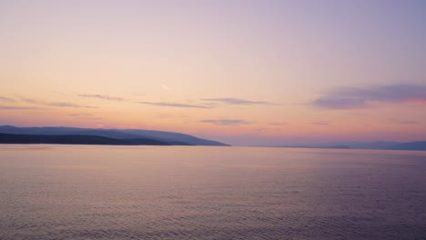 sunrise, sunset over open adriatic sea with coast visible in the background