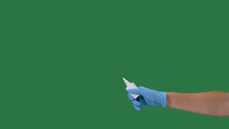 male hands in protective gloves press a bottle of nasal medicine with disinfectant spray. coronovirus protection. preventing a pandemic covid 2019. green screen, chroma key. slow motion. close up