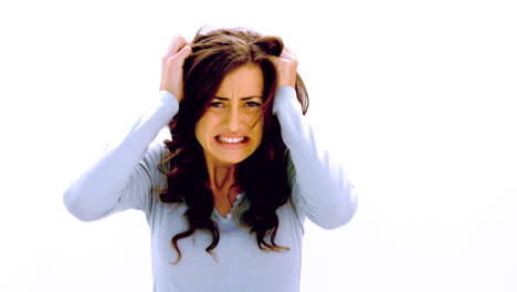 brunette shaking head and pulling at hair with anger