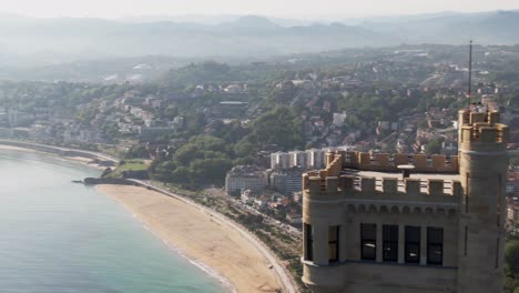 majestuosa torre medieval y horizonte de la ciudad de san sebastián, vista aérea cinematográfica