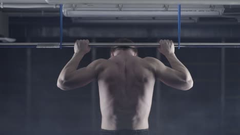 hombre haciendo pull-ups en un gimnasio