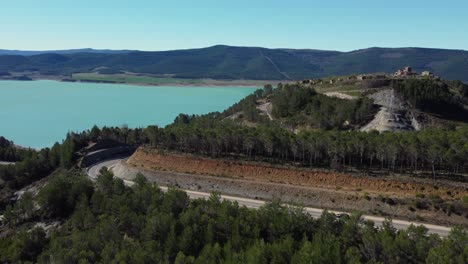 Autos-Umrunden-Die-Autobahnkurve-Auf-Dem-Weg-Zum-Reservoir-Village-In-Spanien