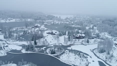 Aerial-view-of-a-snowy-winter-landscape-with-houses-forming-a-small-village