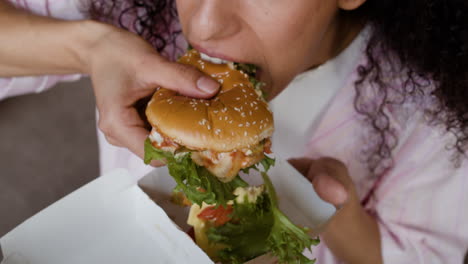 woman eating a large burger
