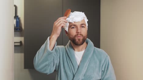 a cute adult man combs his foam hairdo