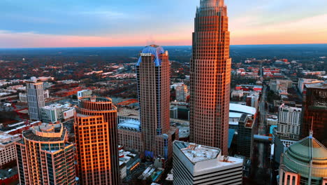 facades of beautiful skyscrapers in the orange light of sunset. distancing from high-rise building in charlotte, north carolina, usa