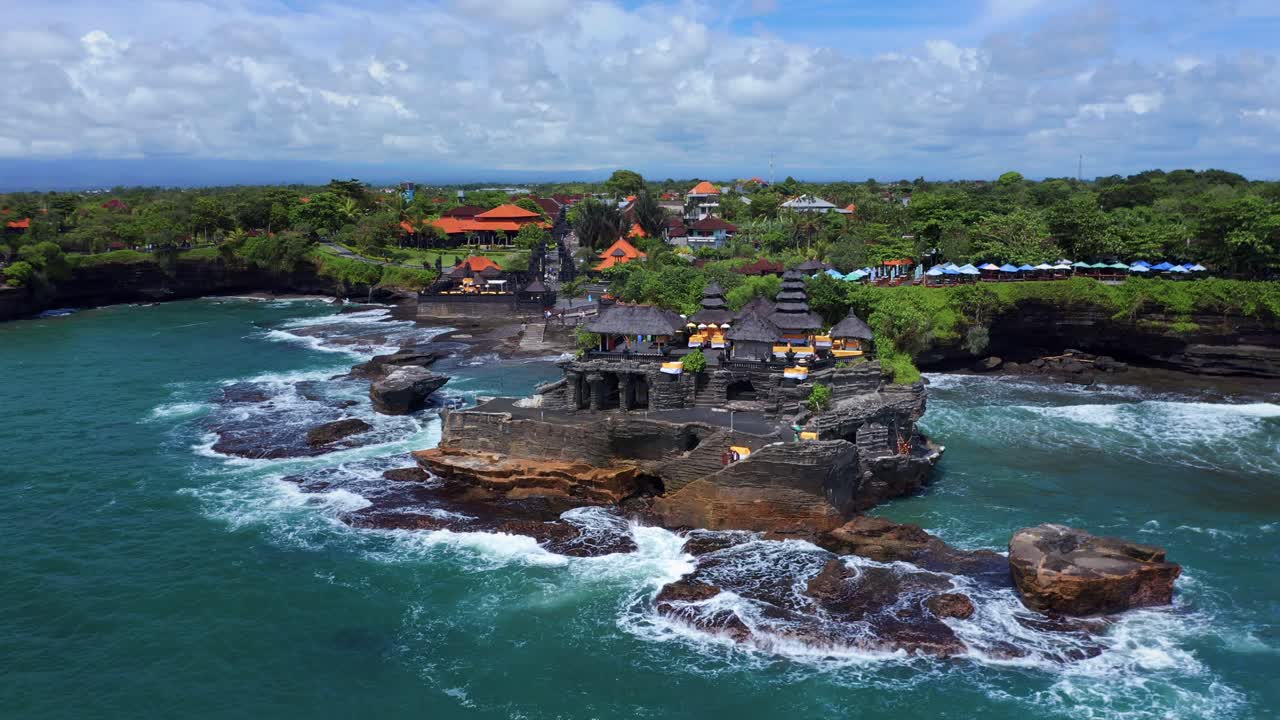 ondas do oceano batendo na ilha rochosa com tanah lot, templo tradicional balinês em bali, indonésia