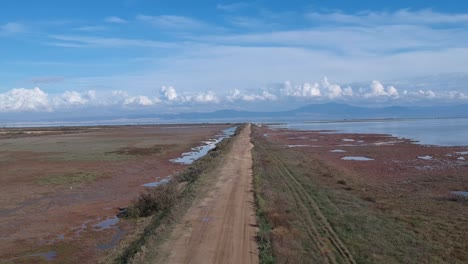 Drohnenaufnahmen-Aus-Der-Luft-über-Dem-Axios-Fluss-Und-Einer-Unbefestigten-Straße-In-Thessaloniki,-Griechenland,-Eines-Flussdeltas,-Das-Zum-Mittelmeer-Führt-Und-Einen-Sumpfartigen-Fußabdruck-Hinterlässt