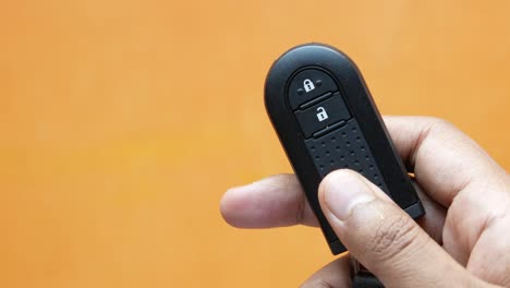 close-up of a hand holding a black car remote key