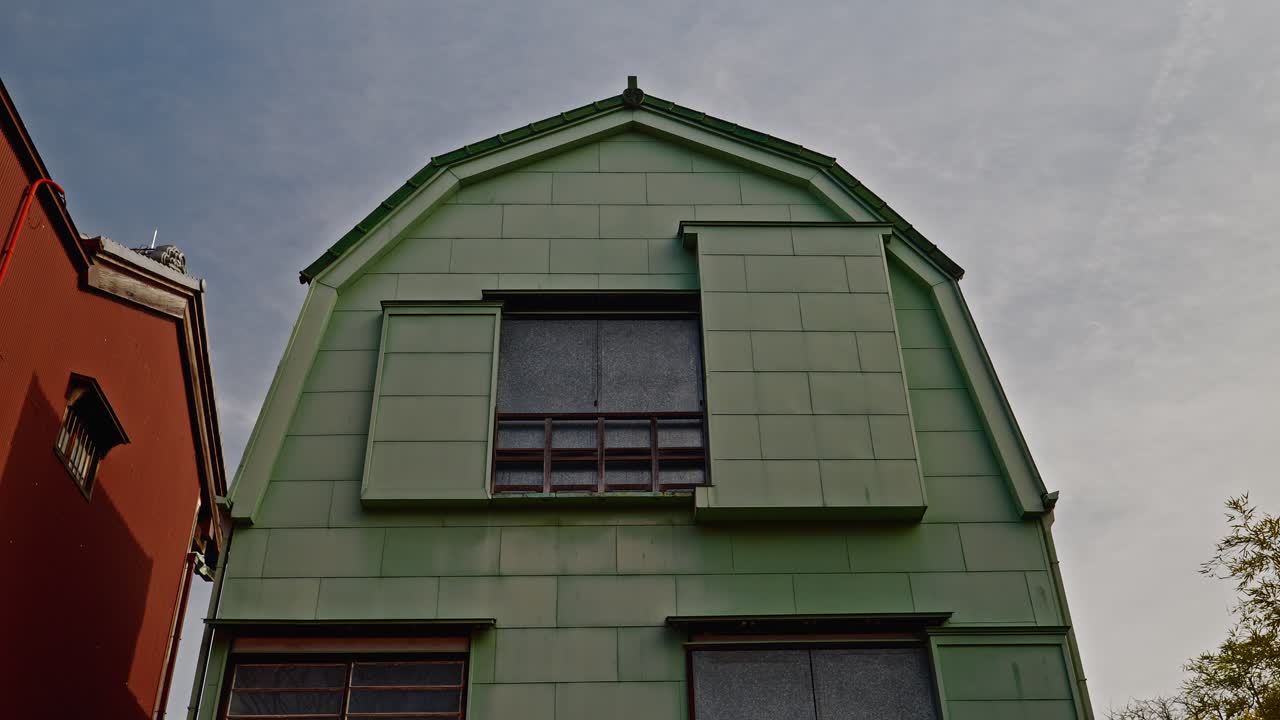 A steady low angle of a historic Showa-era "Kanban Kenchiku" building at Edo-Tokyo Open Air Museum, showing its iconic green copper plate exterior