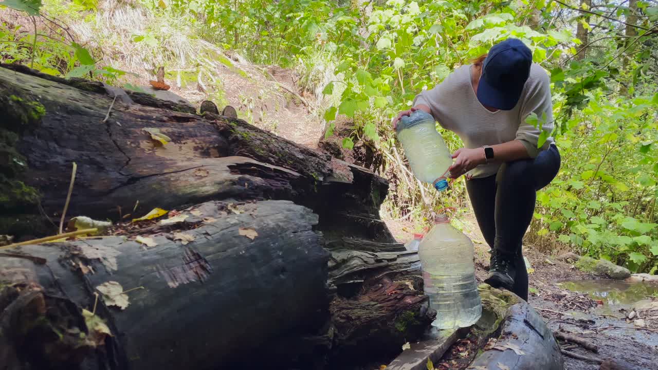 멕시코 네바도 데 콜리마 화산 국립 공원에서 물로 플라스틱 갤런을 채우는 여성