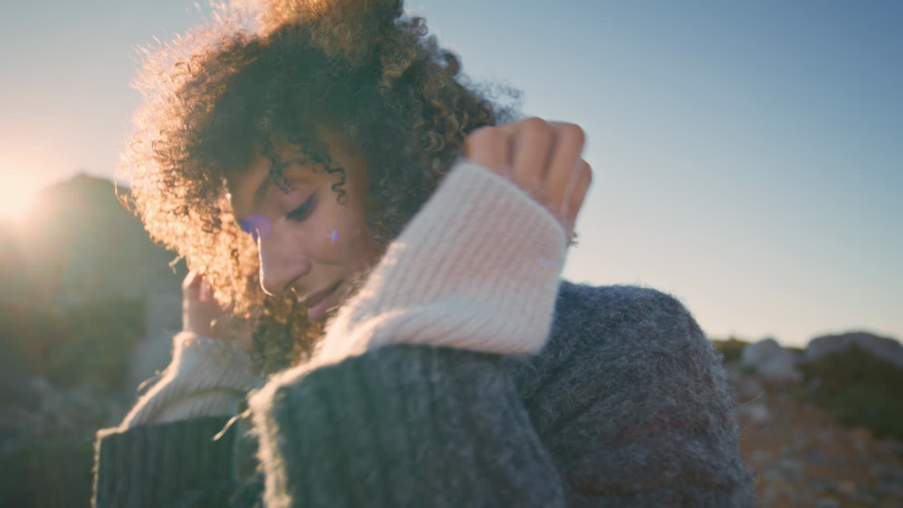 Romantic lady touching curls relaxing at ocean cliff edge closeup. Woman resting
