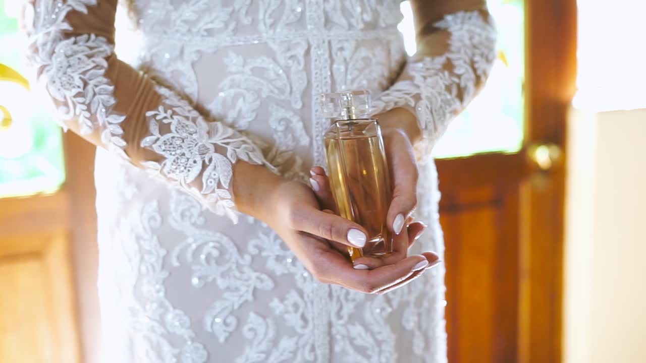 Bride holding perfume, close up