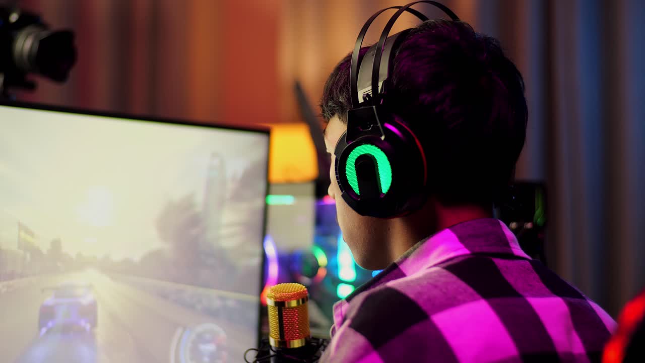 Close Up Back View Of Asian Boy Streamer Screaming Goal Celebrating Winning Car Racing Game Over Network On Personal Computer.  Live Stream Video Game, Desk Illuminated By Rgb Led Strip Light