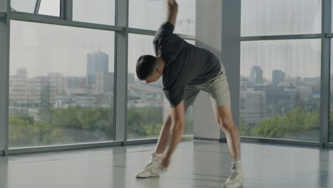 man stretching and dancing in a modern gym