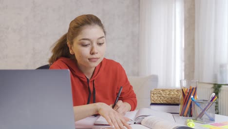 Chica-Estudiante-Universitaria-Estudiando-Felizmente-En-Casa.